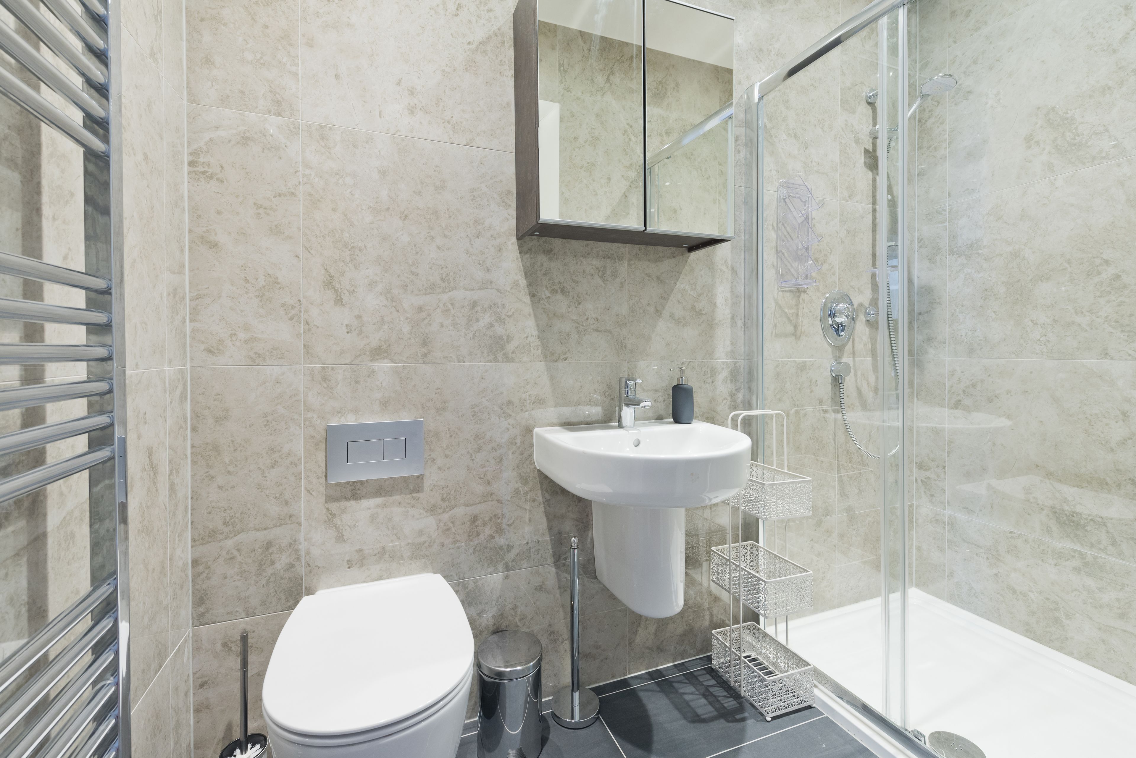A modern bathroom with a glass shower enclosure, a white sink, and a toilet.