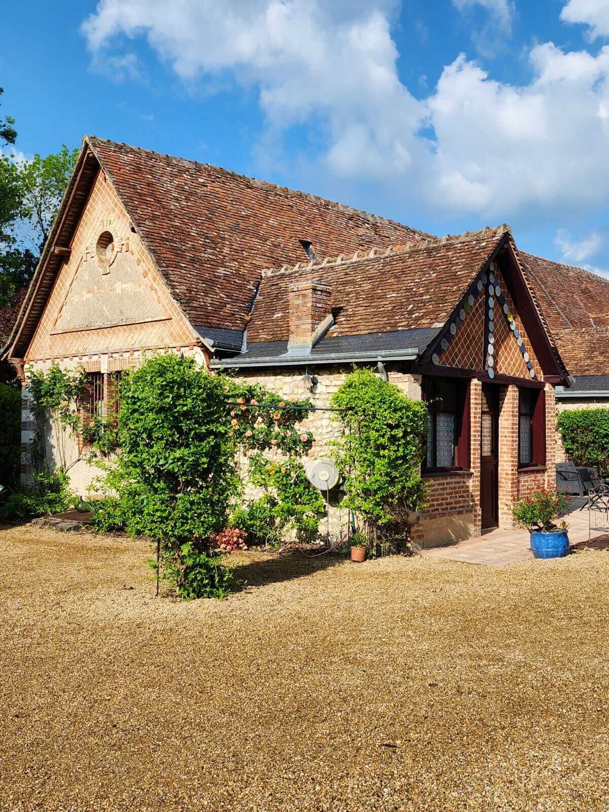 A traditional brick building with a sloped roof and a triangular gable.