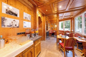 A wooden interior with a bar area, seating, and framed pictures on the walls. - Strandhotel zur Promenade (Binz)