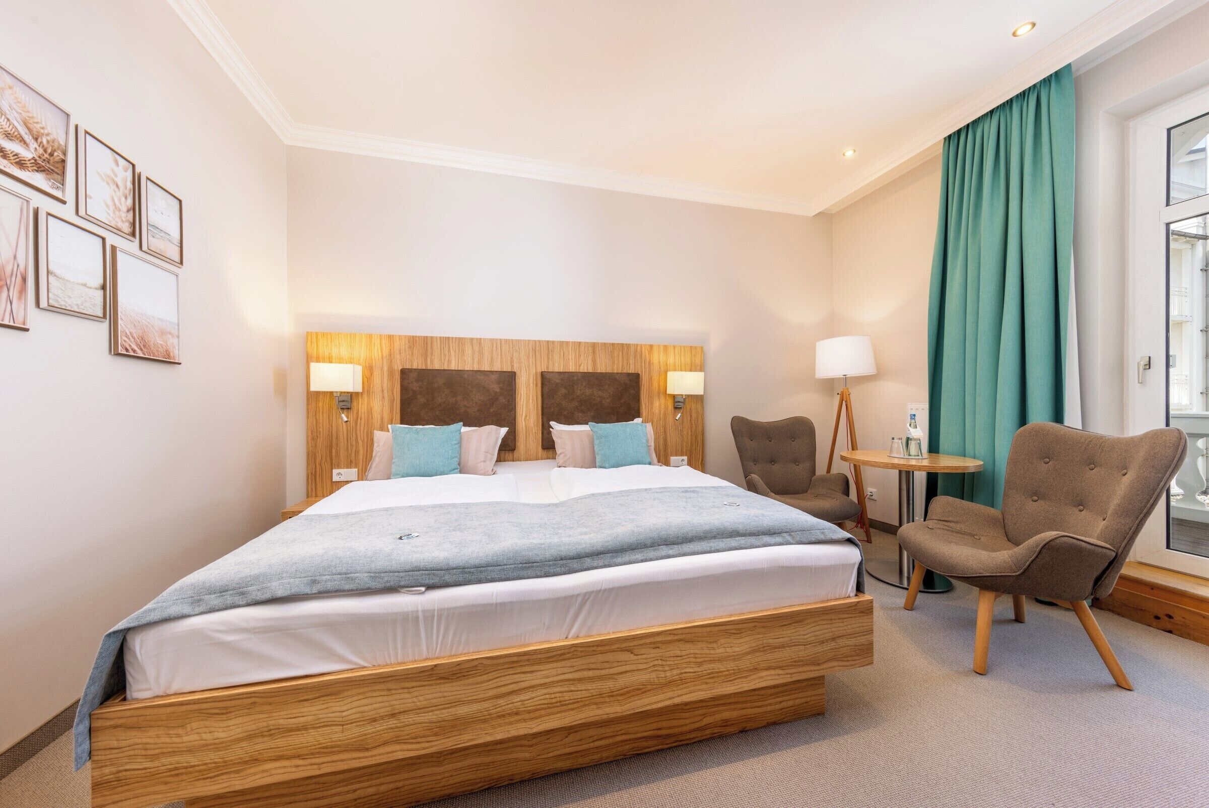 A hotel room with a large bed, two bedside tables with lamps, a chair, and a small table with a lamp.