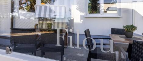 A restaurant window with the name "Filou" and the text "Restaurant am Meer".