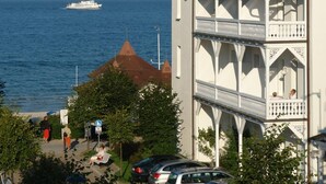 Un bâtiment situé sur la côte, doté d’un dôme et d’un balcon bien visibles, et qui est adjacent à une étendue d’eau où se trouve un bateau.