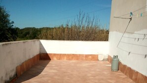 A rooftop patio with terracotta tiles, a gas cylinder, and a white wall with a power outlet. - Campanedda (SS): Villa 10 'from the sea: app. 1 (Sassari)