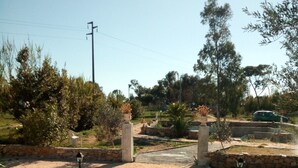 A pathway leading to a gated entrance with a stone wall and a lamp post. - Campanedda (SS): Villa 10 'from the sea: app. 1 (Sassari)