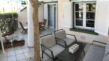 Un espace patio aménagé avec du mobilier d’extérieur, une table et des plantes en pot.