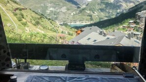 A mountain view from a window with a view of a valley, a lake, and a mountain range. - Horizon 2000 (Le Lac) by Interhome (Tignes)