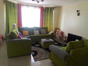 Habitación Deluxe con 1 cama matrimonial o 2 individuales, 2 camas individuales | Sala de estar | Smart TV de 50 pulgadas con canales vía satélite, televisión y Netflix