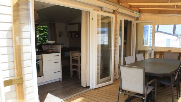 Porta scorrevole aperta che dà su una cucina con lavello, mobili e finestra.