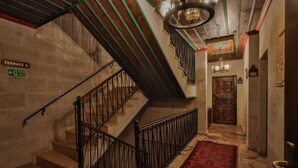 A staircase with a red carpet, a sign indicating a terrace exit, and a door with the number 201. - Feel Cappadocia Stone House (Nevsehir)