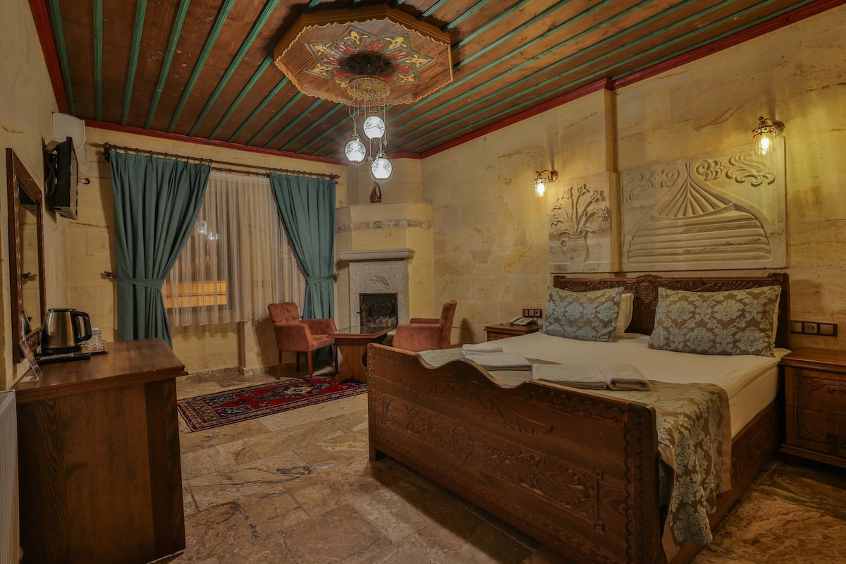 Un dormitorio con cama de madera, chimenea, escritorio y candelabro.