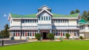 A large, two-story building with a symmetrical facade, a central entrance, and a green lawn in front. - Adb Rooms The Oak Tree House (Shimla)