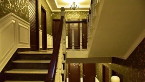 A grand staircase with a black and white checkered floor, leading to a landing with a chandelier. - Adb Rooms The Oak Tree House (Shimla)