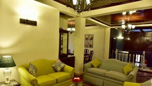 A living room with two green sofas, a coffee table, and a lamp. - Adb Rooms The Oak Tree House (Shimla)
