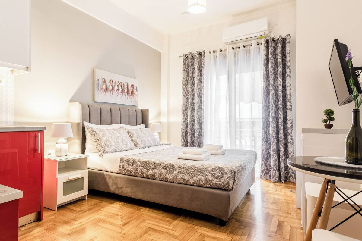 Un dormitorio con cama, mesitas de noche, escritorio y silla.