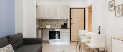 A modern apartment with a living area, kitchenette, and dining space.