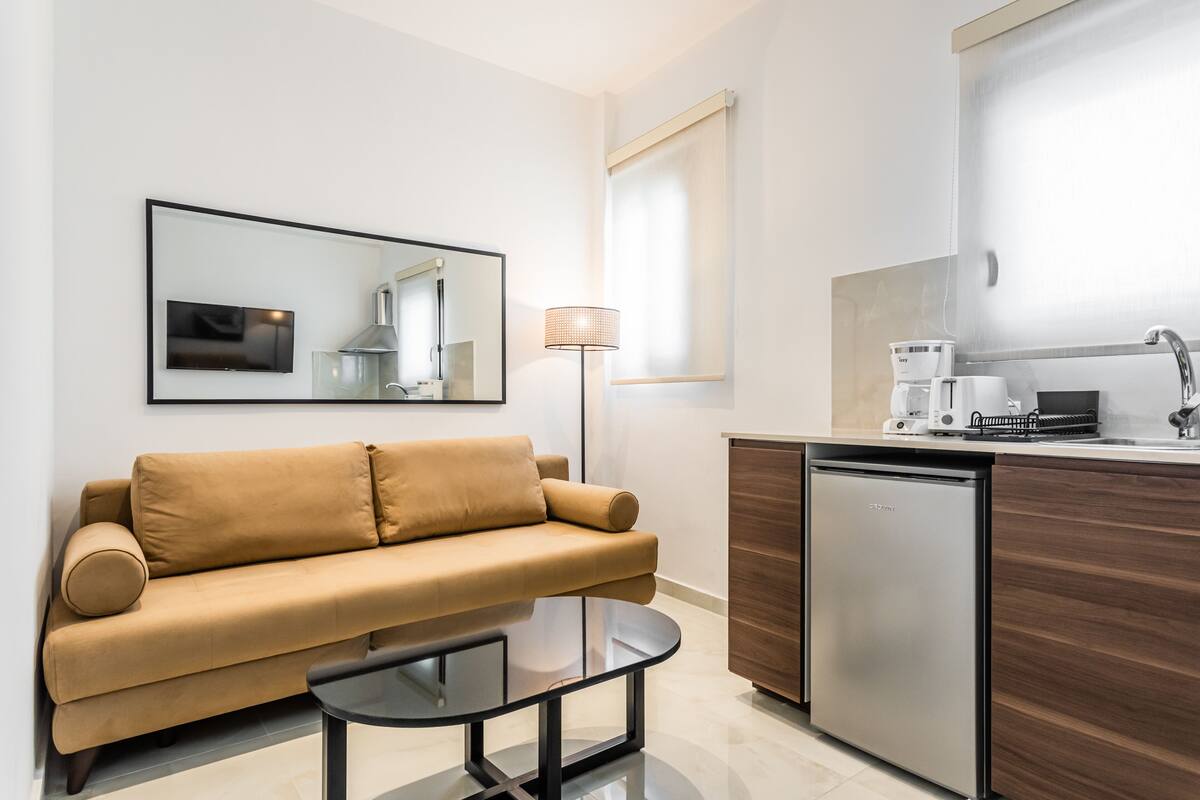 Una sala de estar moderna con un sofá, una cafetera y un lavavajillas.