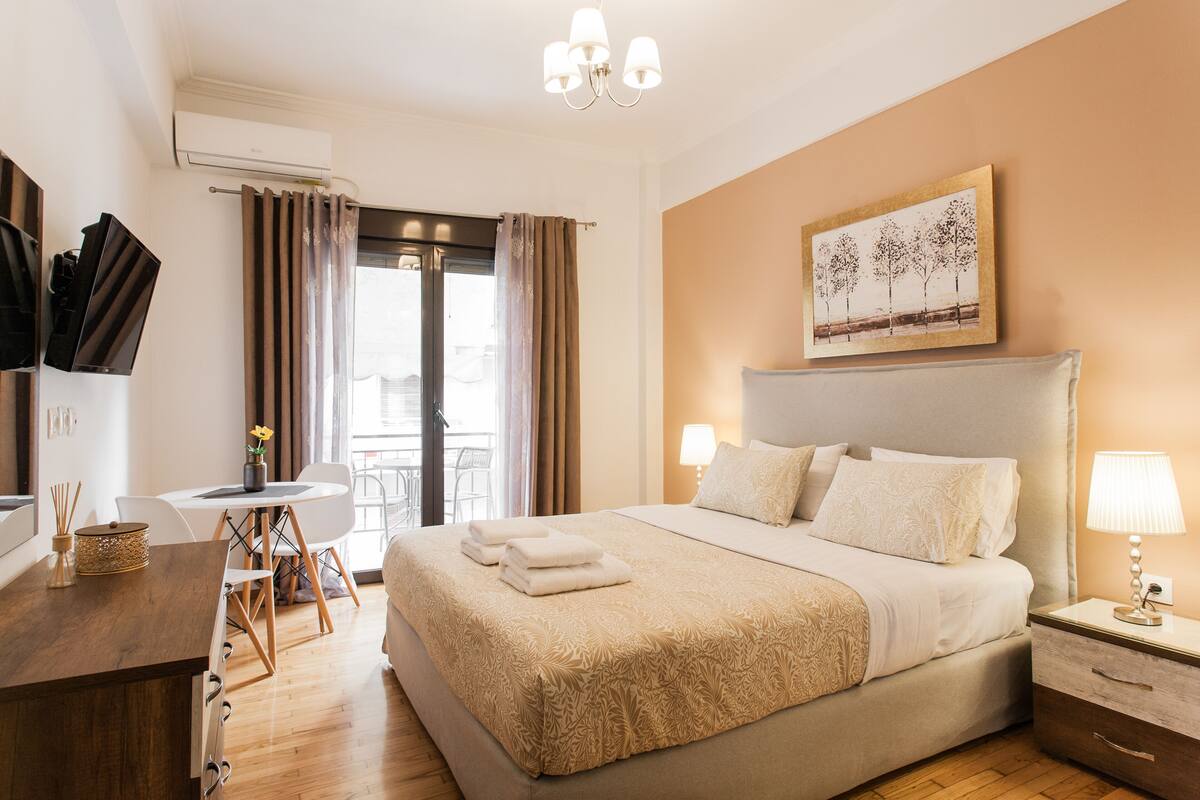 Habitación de hotel con cama, mesita de noche, lámpara y un cuadro en la pared.