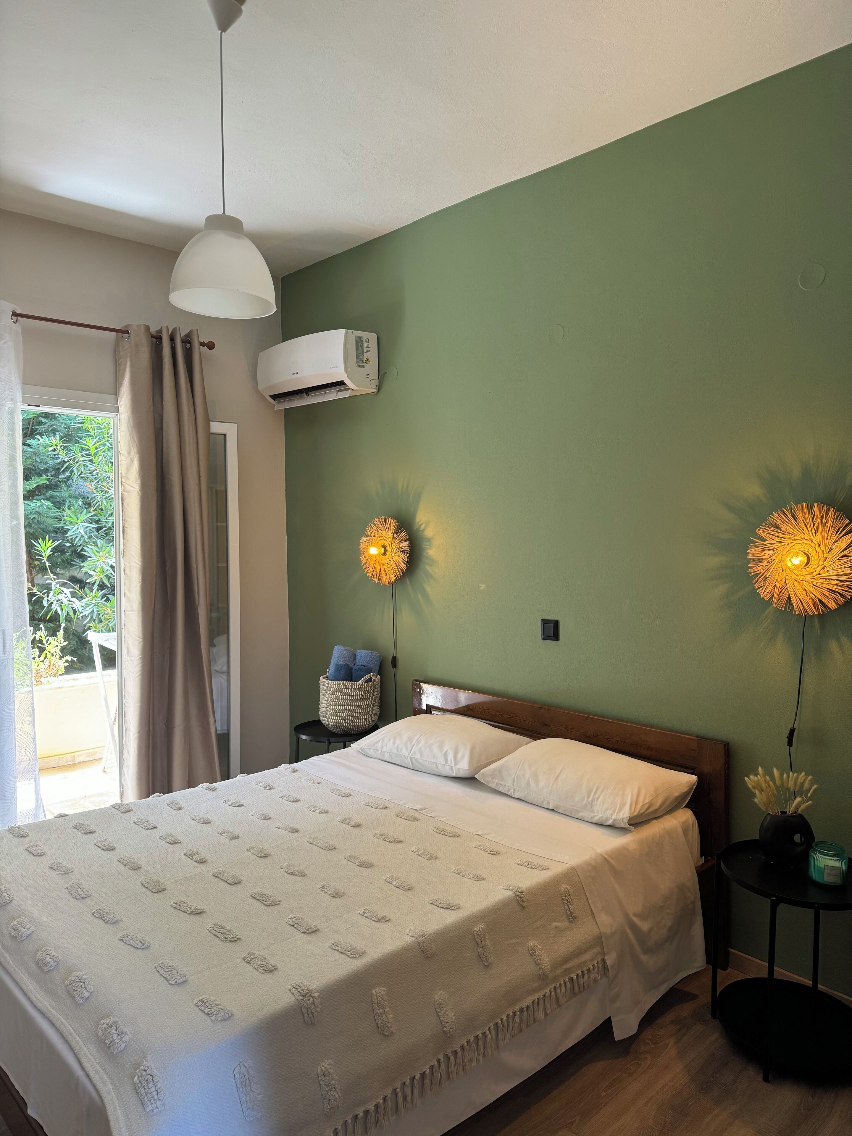 Una camera da letto con un letto, un comodino, un condizionatore d'aria e due lampade a parete.