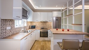 A modern kitchen with white cabinets, a wooden countertop, a built-in oven, and a stainless steel refrigerator. - Villa Hill, 2 bedroom villa with breathtakig view and private pool! (Zakynthos)
