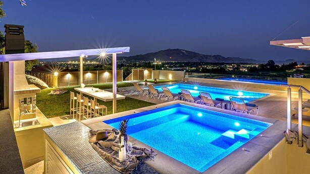 A swimming pool area with multiple pools, lounge chairs, and a bar area. - Villa Hill, 2 bedroom villa with breathtakig view and private pool! (Zakynthos)