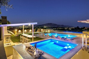 A swimming pool area with multiple pools, lounge chairs, and a bar area. - Villa Hill, 2 bedroom villa with breathtakig view and private pool! (Zakynthos)