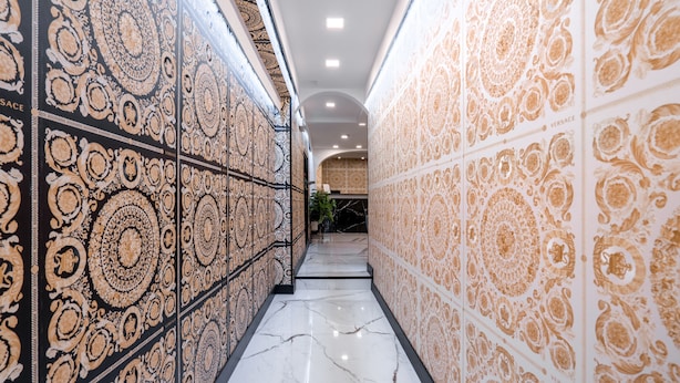 A hallway with patterned walls and a marble floor. - Hotel Deco (Florence)