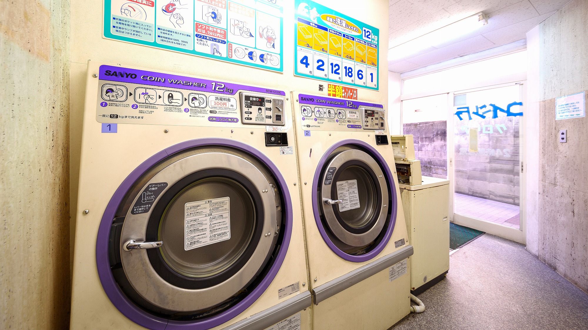 A coin-operated washing machine with instructions and a 12kg capacity label.