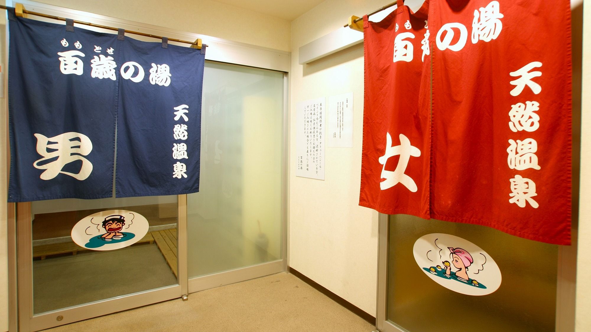 A hallway with two doors, each adorned with a blue and red towel hanging on the door handles.