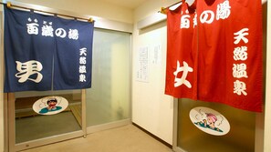 A hallway with two doors, each adorned with a blue and red towel hanging on the door handles. - New Gloria Oita Hotel (Oita)