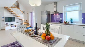 Une cuisine moderne dotée d’un îlot central, d’une cuisinière intégrée et d’une grande fenêtre.
