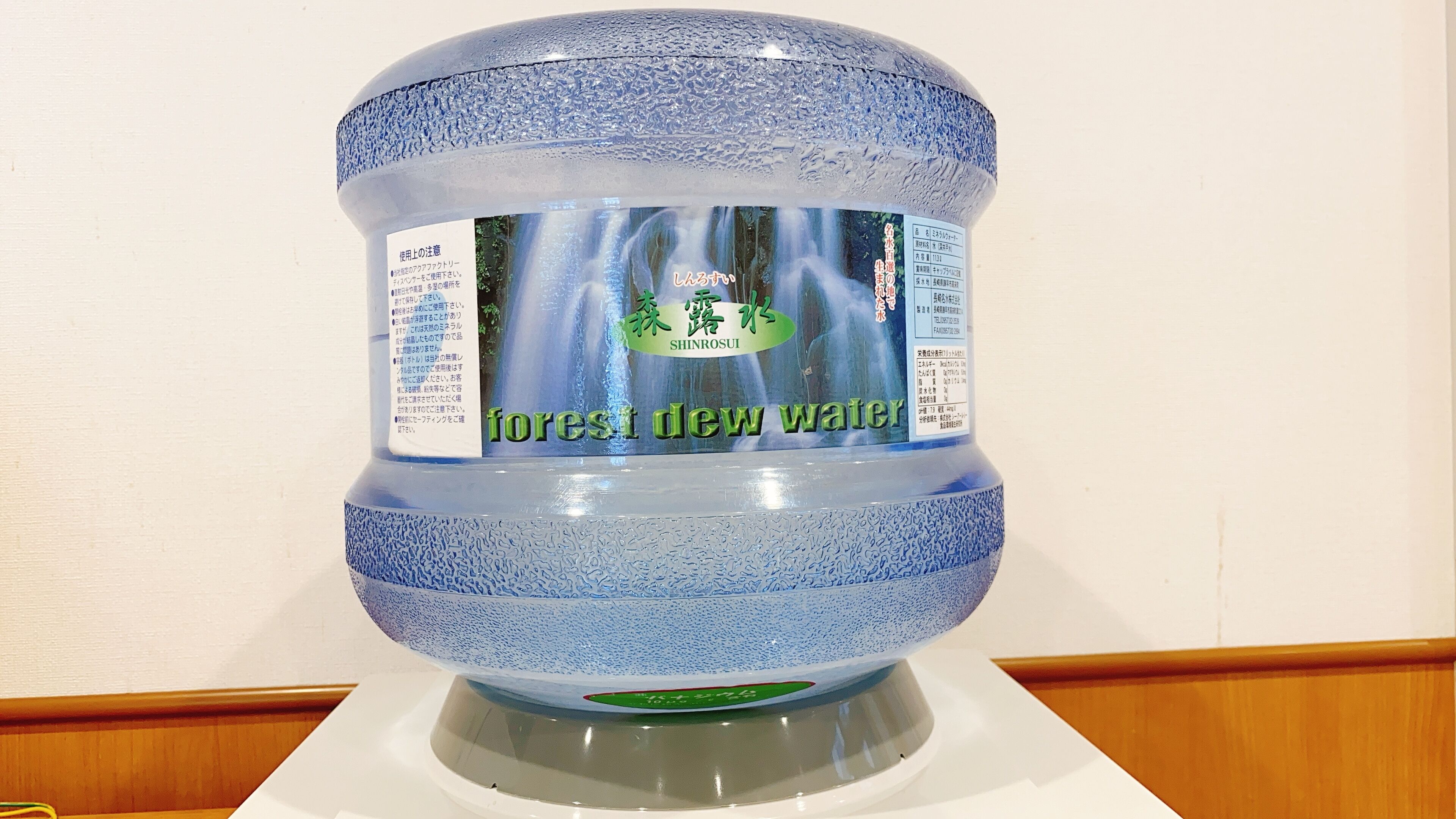 A large water dispenser with a label that includes the text "forest dew water."