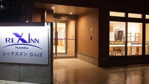A sign for a hotel named Rex Inn with a visible entrance and interior view through large windows. - REX INN Namba (Osaka)