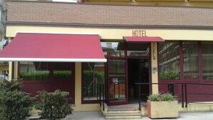 A hotel entrance with a red awning, glass doors, and a visible address sign. - Hotel Nuova Doel (Chioggia)