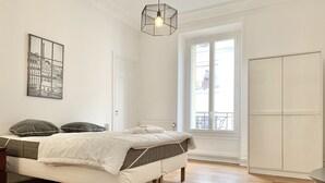 Et soveværelse med seng, et natbord, et vindue med udsigt og en dør.