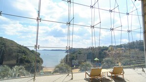 A balcony with a view of a lake, surrounded by greenery and a clear sky. - Resort Club Iseshima (Shima)