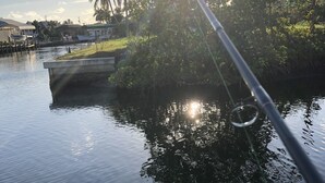 A calm water body with a fishing rod and a concrete structure.