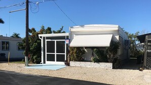 A single-story building with a small porch and a sliding glass door.