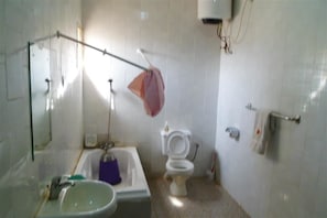 Bathroom features a sink, bathtub, shower curtain, and toilet, along with a towel rack and mirror.