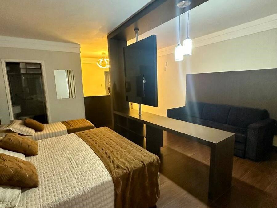 Una habitación de hotel moderna con dos camas, un sofá, un televisor y un escritorio.