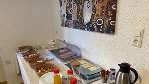 A breakfast buffet with various food items, including bread, pastries, and beverages. - Gästehaus Häuser (Linden)