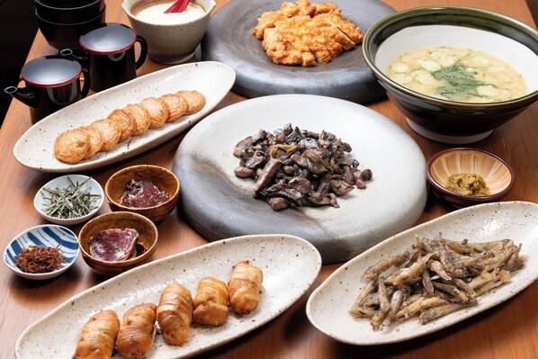 A variety of dishes on a wooden table, including a bowl of soup, plates of food, and several small bowls with condiments. - Richmond Hotel Miyazaki Ekimae (Miyazaki)