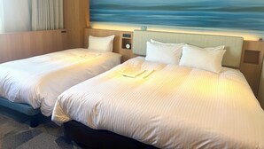Una camera d'albergo con due letti, un quadro raffigurante un mare tranquillo, una sveglia e un piccolo ripiano con un orologio.