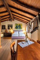 Quarto rústico de madeira com cama, mesa de jantar e lustre.