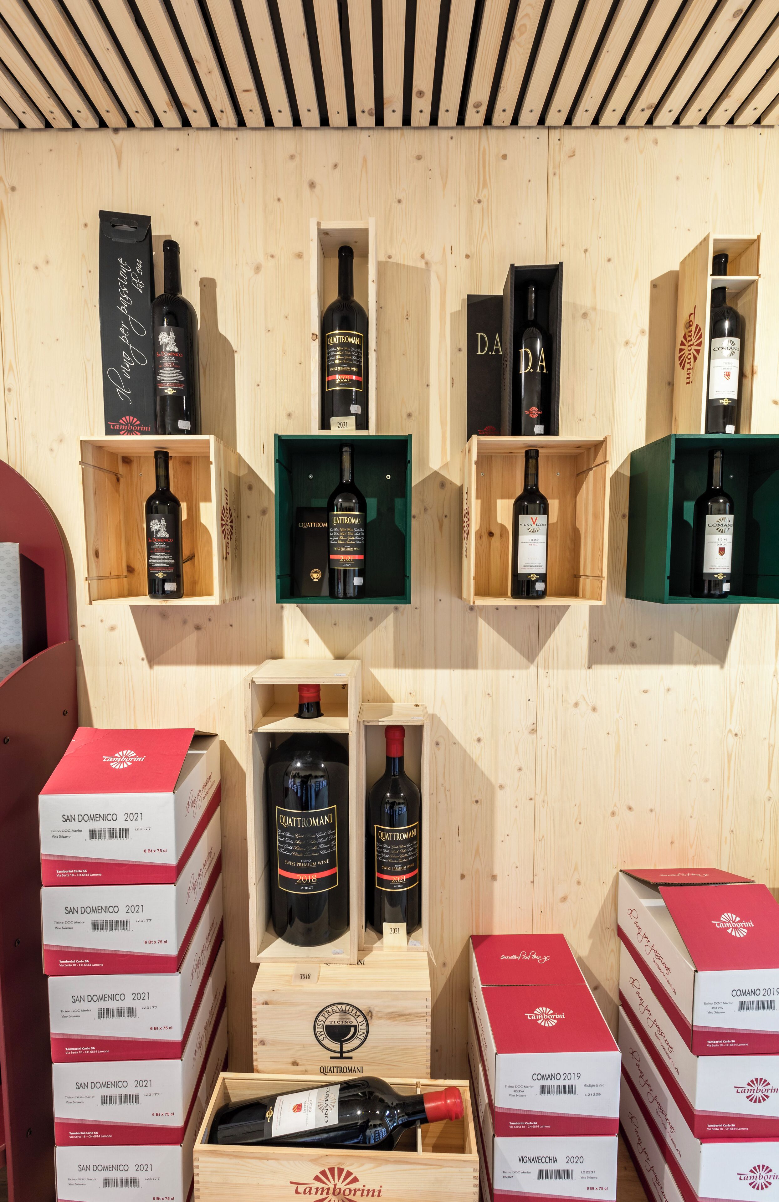 Una vitrina de madera exhibe varias botellas y cajas, algunas con la etiqueta 'San Domenico 2021'.