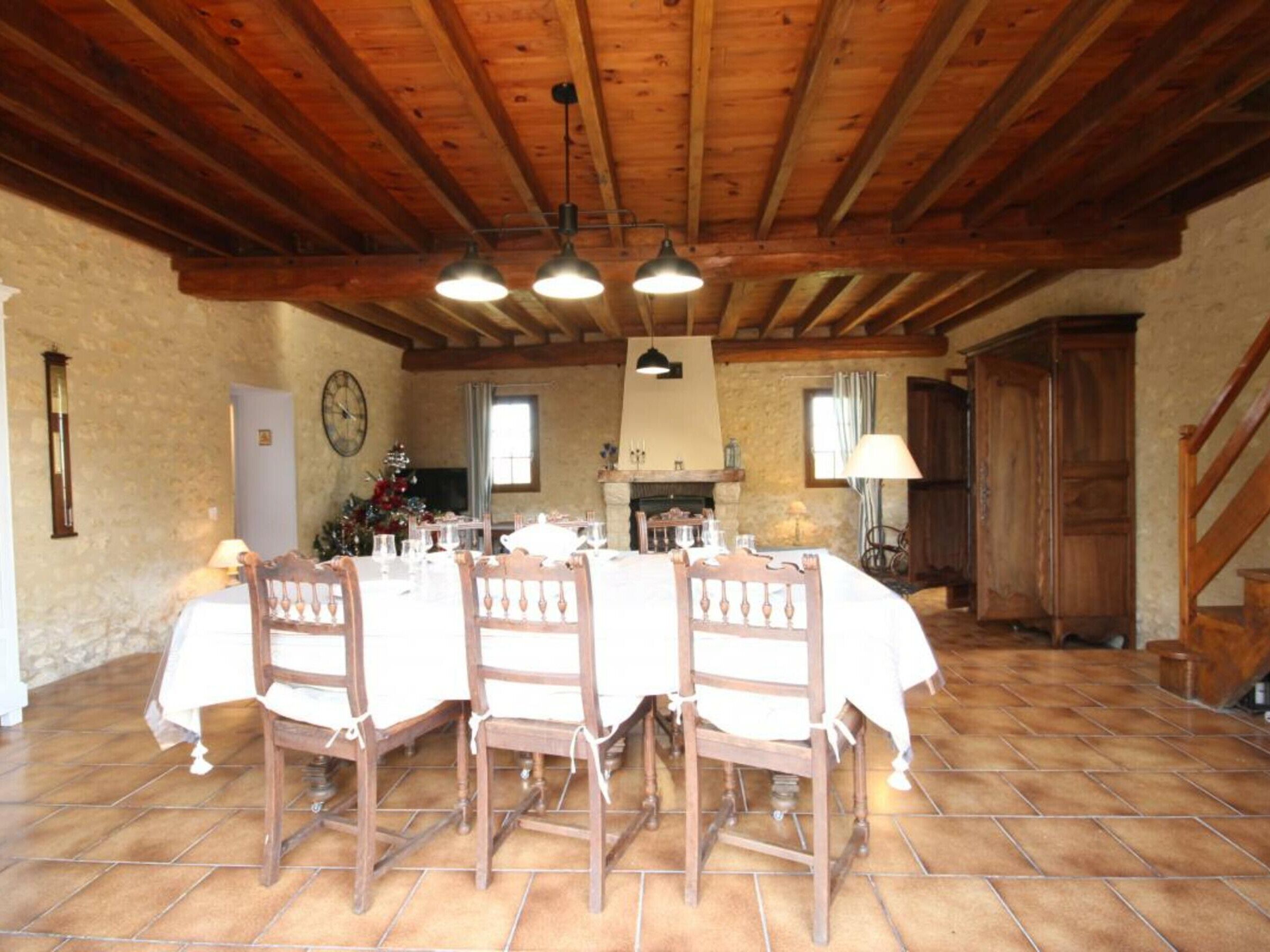Comedor con una mesa de madera dispuesta para cuatro personas, rodeado de sillas.