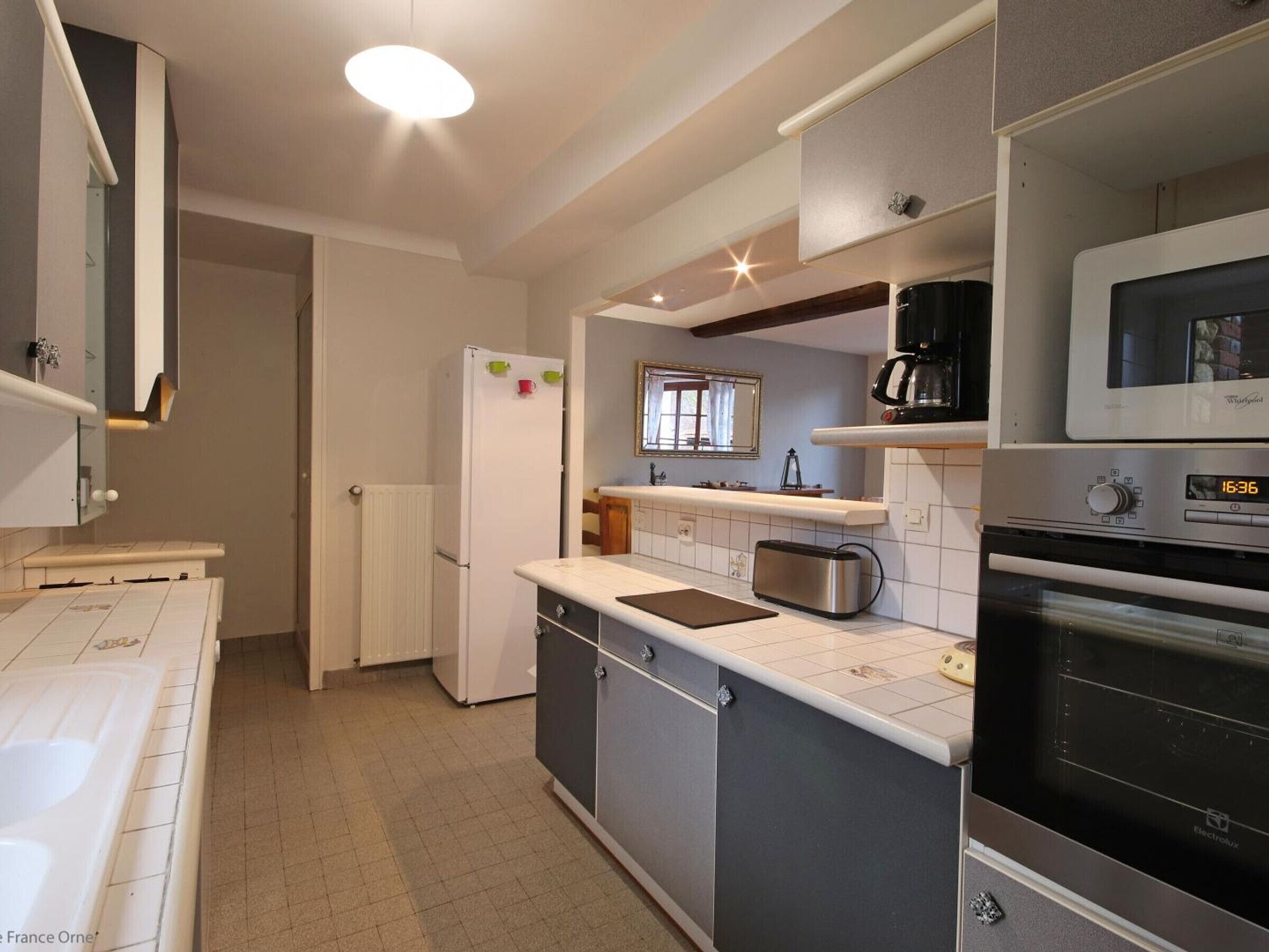 Eine moderne Küche mit Kühlschrank, Toaster, Mikrowelle und Backofen.