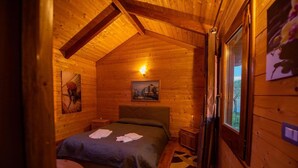 A cozy wooden room with a bed, a painting, and a window. - Agriturismo Il Borgo sul Lago (Maierato)