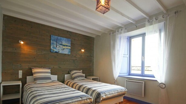 A room with two beds, wooden flooring, a painting on the wall, and a window with curtains. - Family house in the heart of Perche - 11 guests (Feings)