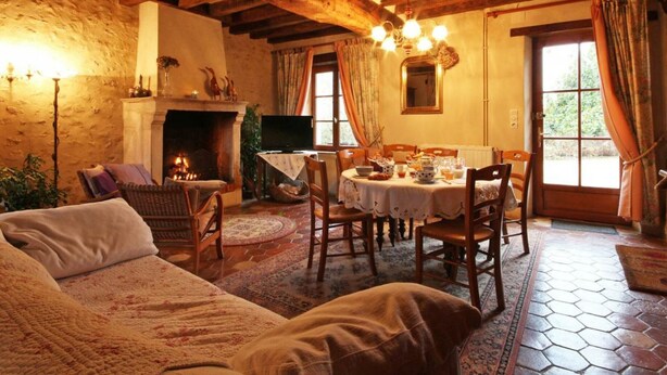 Ein gemütliches Zimmer mit Kamin, Esstisch und Fernseher.