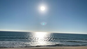 Una playa con el sol reflejado en el agua.